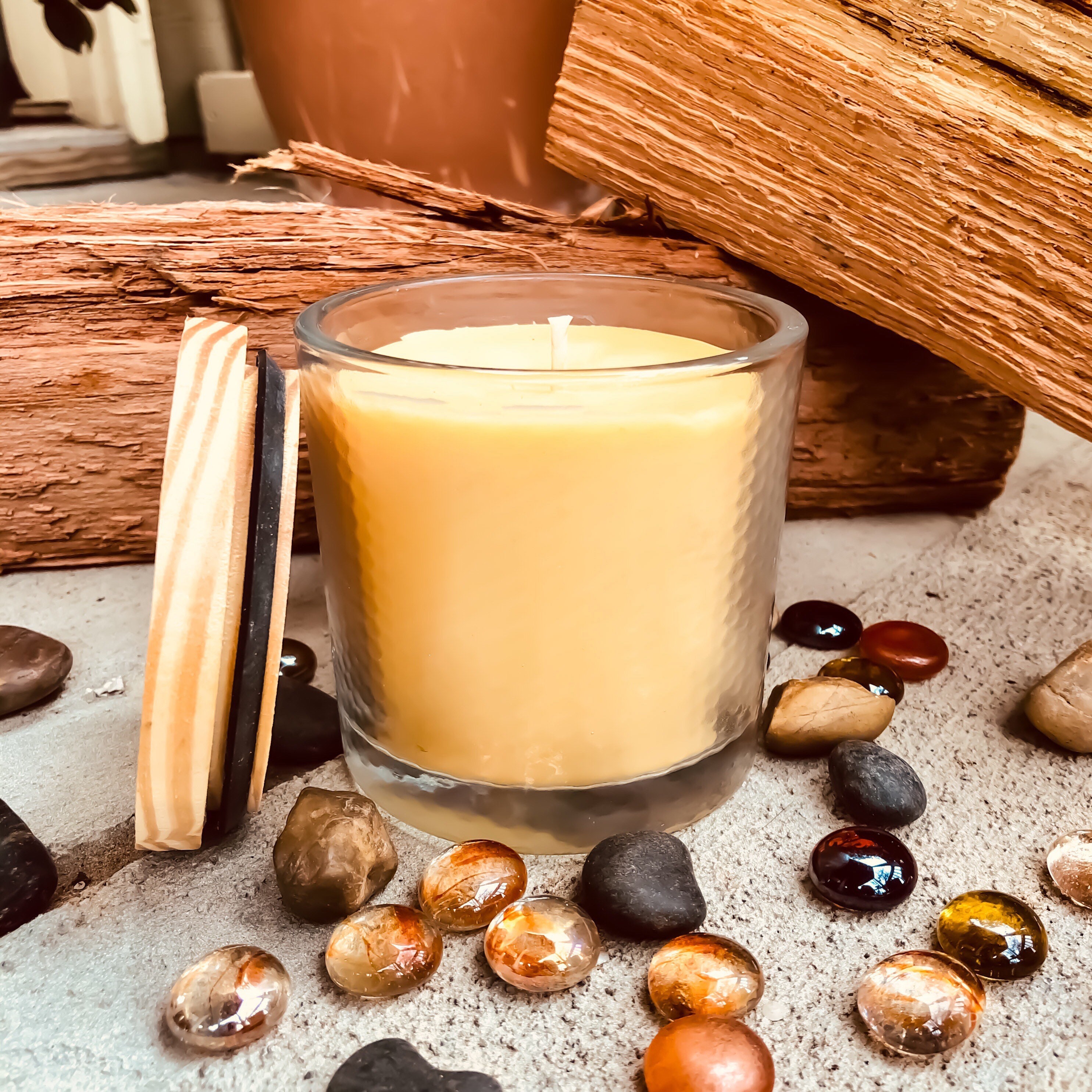 Pure organic beeswax candle in a large glass jar topped with wooden lid
