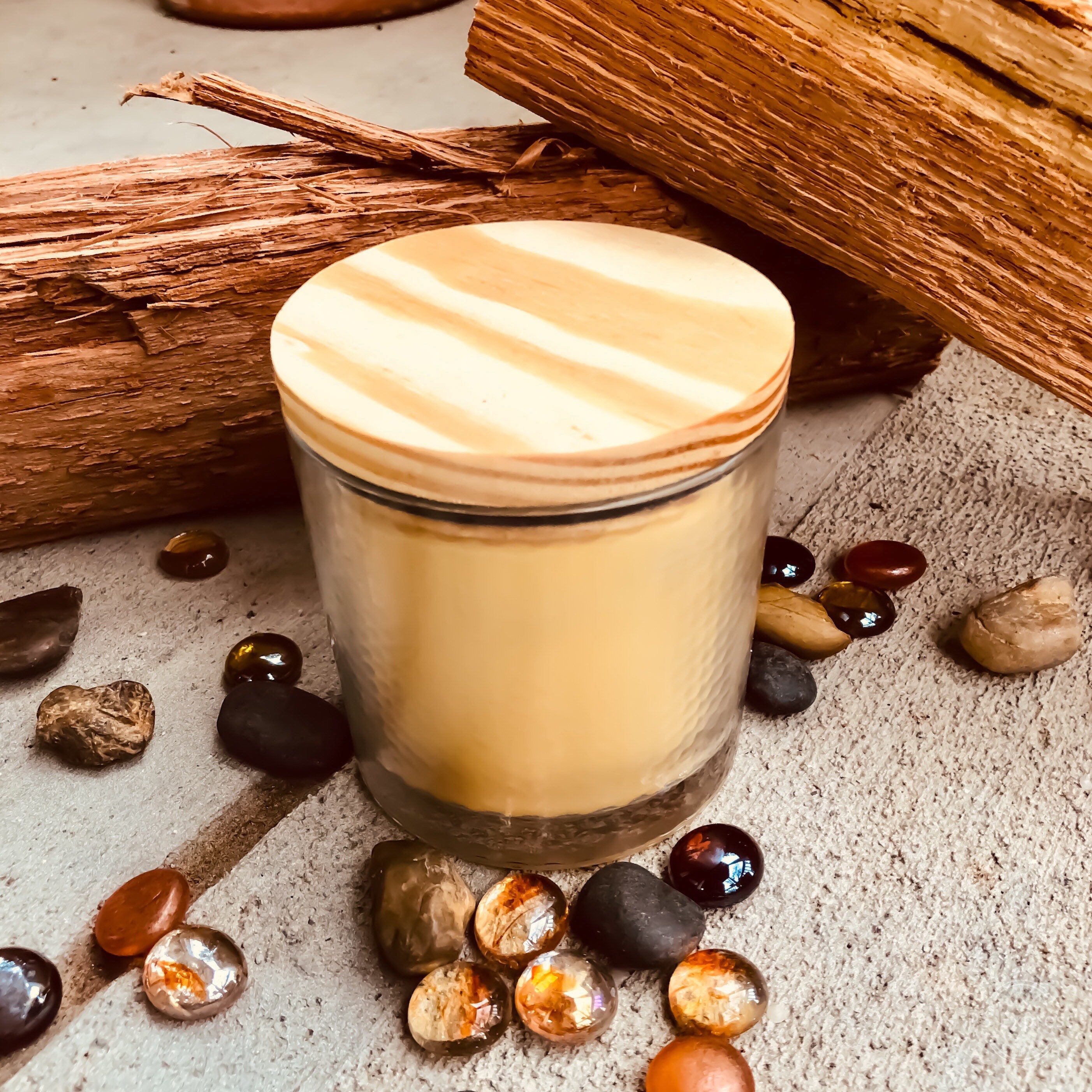 Pure organic beeswax candle in a large glass jar topped with wooden lid