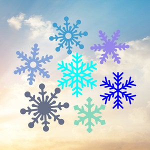 Könnte beinhalten: Sieben Schneeflocken in verschiedenen Farben vor einem bewölkten Himmel. Die Schneeflocken sind blau, lila, türkis und grau.