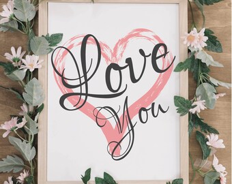 May include: A white framed print with a pink heart and the words "Love You" in black cursive script.
