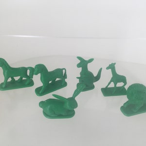 Könnte beinhalten: Ein Set mit sechs grünen Tierfiguren aus Plastik. Die Tiere sind ein Einhorn, ein Pferd, ein Känguru, eine Giraffe, ein Kaninchen und ein Löwe.