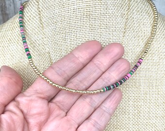 Gold filled beaded necklace with rainbow vinyl accent.