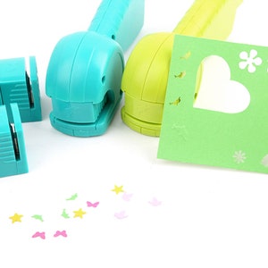 May include: Two handheld paper punch tools, one blue and one green, with a variety of paper shapes punched out, including stars, butterflies, and hearts.