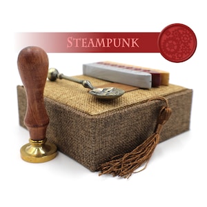 May include: A brown wooden box with a burlap lid and a brown tassel. The box contains a set of wax seals, a spoon, and a wax stick. The box is labelled "STEAMPUNK".
