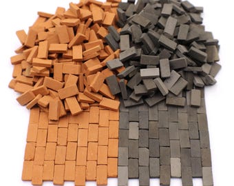 Könnte beinhalten: Ein Haufen kleiner, orangefarbener und grauer Ziegel aus Bastelmaterial. Die Ziegel sind in zwei Haufen angeordnet, einer orange und einer grau. Die orangefarbenen Ziegel sind unten links in einem Muster angeordnet, und die grauen Ziegel sind unten rechts in einem Muster angeordnet.