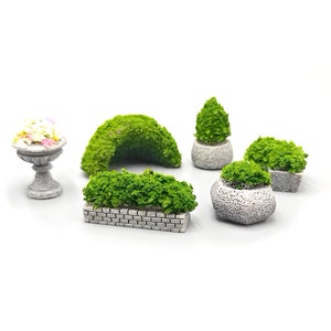 Pode incluir: Um conjunto de seis itens decorativos de jardim em miniatura, incluindo um vaso de pedra com um arbusto verde, um arco de pedra com um arbusto verde, um vaso de pedra com um arbusto verde, um vaso de pedra com um arbusto verde, um vaso de pedra com um arbusto verde e um vaso de pedra com um arbusto verde.