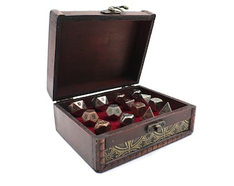 May include: A wooden treasure chest with a gold and black floral design on the lid is open, revealing a set of metal dice in silver, copper, and bronze.