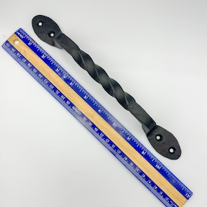 May include: Black metal twisted handle with two holes for mounting. The handle is approximately 18 cm long and is measured against a ruler.