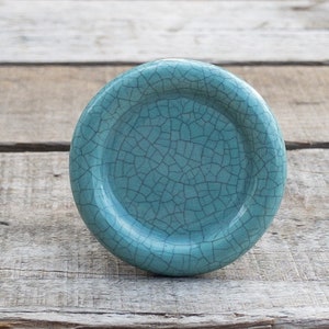 May include: A round, teal ceramic knob with a crackled glaze finish.