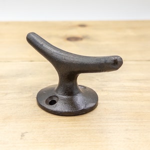 K&ouml;nnte beinhalten: Ein schwarzer Bootshaken aus Gusseisen. Der Haken ist in Form eines Bootshaken geformt und hat eine runde Basis.