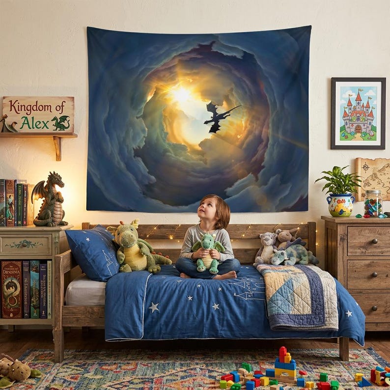 May include: A child sits on a bed with a blue comforter, looking up at a tapestry depicting a dragon flying through clouds. The room features a wooden bed frame, dresser, and a sign that reads "Kingdom of Alex."