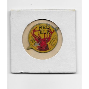 May include: A yellow and red round sticker with a red elk illustration and the text "RED ELK" in a red circle. The text "MARTINVILLE HENRY CO. VA." is on the right side of the sticker. The text "PENN & WATS. IN." is on the left side of the sticker.