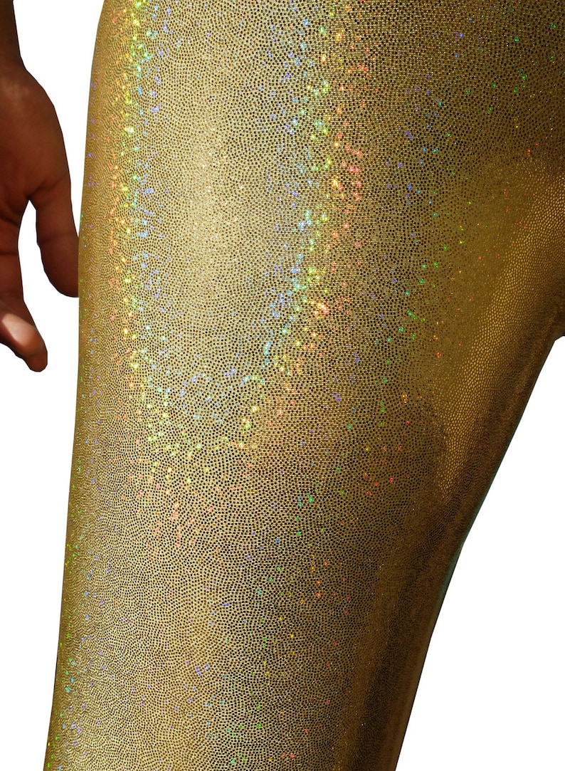 May include: Gold leggings with a shimmery, iridescent finish. The fabric has a textured, almost scaly appearance.