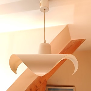 Minimalist light fixture with metal plate and curved ends