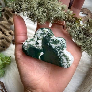 May include: Green and white agate stone carved into a cloud shape. The stone has a swirling pattern of green and white.