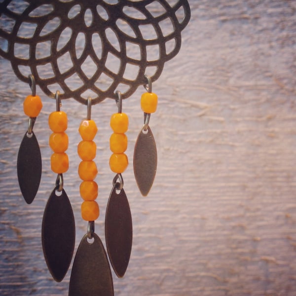 Boucles d'oreilles avec grande estampe dentelée, breloques ovales en laiton et perles facettées oranges. Esprit bohème et gipsy !