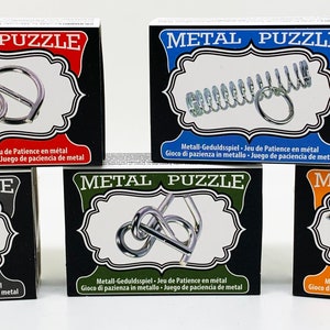 May include: Five metal puzzle boxes, each featuring a different interlocking design. The boxes are black with coloured frames, and the words "METAL PUZZLE" are displayed. Text in multiple languages is also visible.