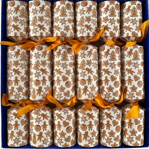 May include: A set of Christmas crackers in a blue box. Each cracker is wrapped in white paper with a repeating pattern of gingerbread men, stars, hearts, and trees in brown. The crackers are tied with gold ribbons.