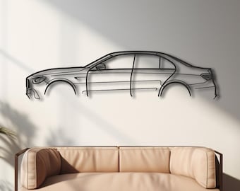 Puede incluir: Una pieza de arte mural minimalista de metal que representa el contorno de un coche, montada en una pared blanca sobre un sofá beige. La obra de arte es un diseño elegante y moderno, perfecto para los entusiastas del automóvil. La habitación tiene luz natural.