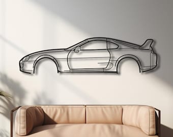 Puede incluir: Una pieza de arte mural de metal negro que representa el perfil lateral de un coche deportivo. La obra de arte está montada en una pared blanca sobre un sofá beige. La habitación tiene suelos de madera y plantas en macetas, creando un diseño interior moderno.