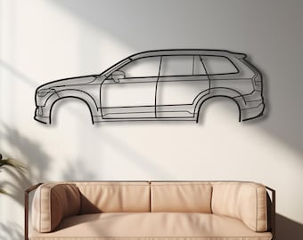 Puede incluir: Una pieza de arte mural de metal que representa el perfil lateral de un coche. La obra de arte es un diseño minimalista, en un color metálico oscuro, y montada en una pared blanca. El contorno del coche está claramente definido, mostrando su forma y características. La habitación tiene un diseño moderno con un sofá y plantas.