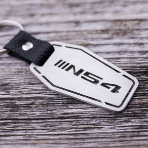 May include: A silver metal keychain with a black leather strap and a silver tag that says "INS4" on it.