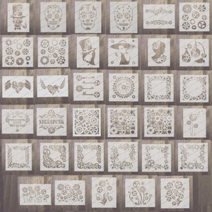 May include: A set of 36 white vinyl stencils featuring steampunk, floral, and skull designs. The stencils are arranged in rows on a wooden background.