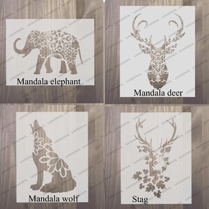 Peut inclure: Quatre pochoirs d'animaux mandala diff&eacute;rents. Les pochoirs sont sur un fond en bois. Les animaux sont un &eacute;l&eacute;phant, un cerf, un loup et un cerf. Les pochoirs sont tous blancs et ont des motifs complexes.