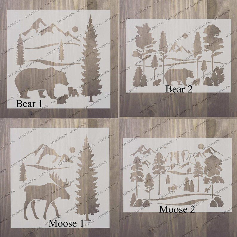 Peut inclure: Quatre pochoirs pour projets d'artisanat, repr&eacute;sentant un ours, un &eacute;lan et un paysage de montagne. Les pochoirs sont blancs et d&eacute;coup&eacute;s sur un fond en bois brun. Les pochoirs sont &eacute;tiquet&eacute;s "Ours 1", "Ours 2", "&Eacute;lan 1" et "&Eacute;lan 2".