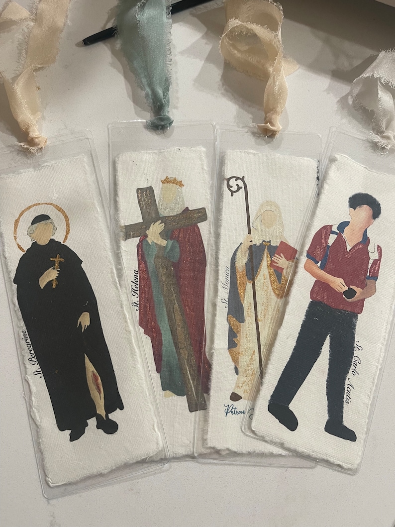Może przedstawiać: Cztery zakładki z r&oacute;żnymi postaciami religijnymi i jedną osobą. Zakładki są wykonane z papieru i mają białe tło. Postacie są namalowane w realistycznym stylu. Zakładki mają r&oacute;żne rozmiary i kształty. Tekst na zakładkach brzmi: "St. Perccrine", "St. Helena", "St. Monica" i "St. Carlo Acutis".