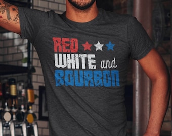 May include: A dark grey heather t-shirt with a distressed red, white, and blue graphic that says "Red White and Bourbon".