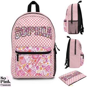 May include: Pink and white checkered backpack with the name "SOPHIA" in a collegiate font. The front pocket features a watercolor design of school supplies. Includes a matching pencil case.