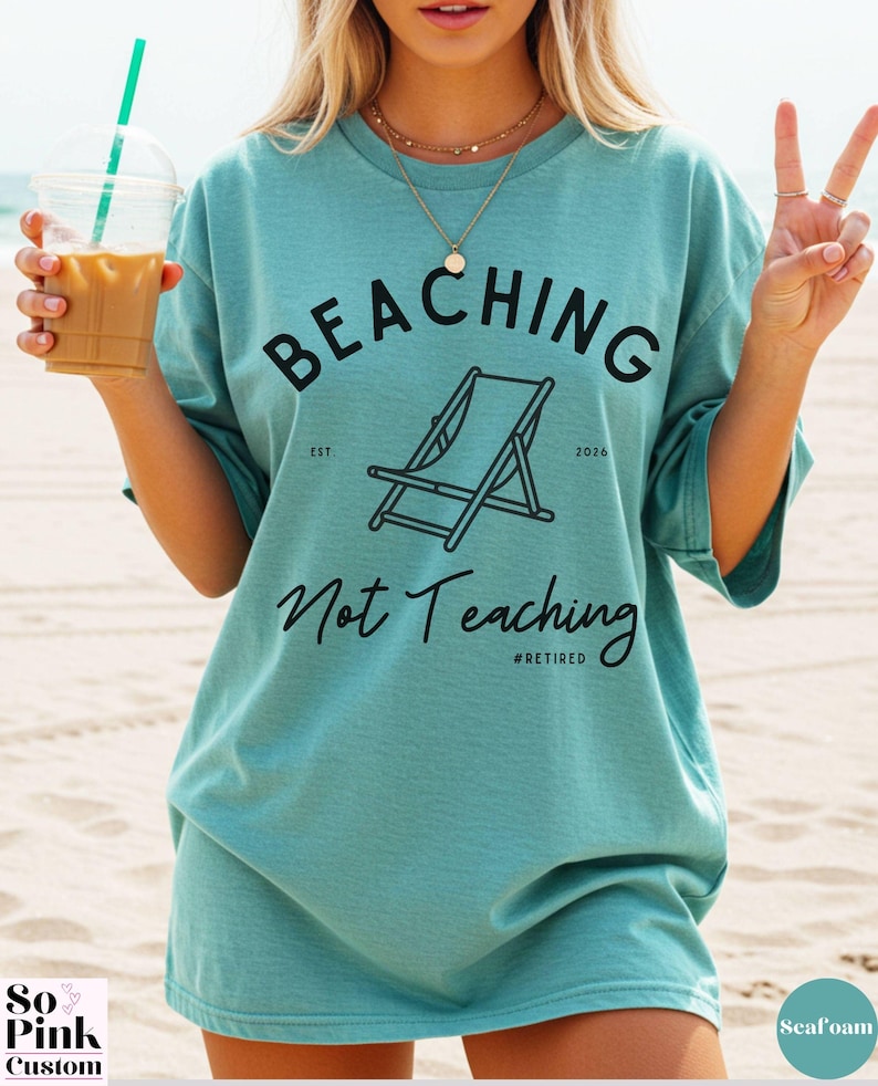 Comfort Colors Shirt with deck chair illustration in the center, curved text above, script below - BEACHING Not Teaching #Retired Year Est. 2026