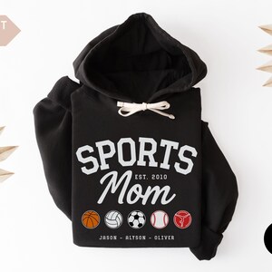 Multiple Sports Mom Hooded Sweatshirt with various sports ball icons, year established and kids names, mixture of college and cursive fonts