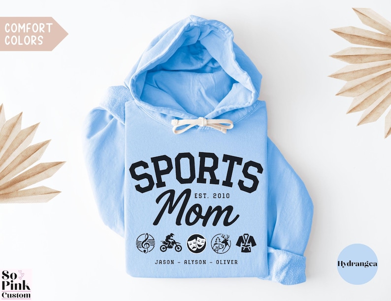 Multiple Sports Mom Hooded Sweatshirt with various sports ball icons, year established and kids names, mixture of college and cursive fonts