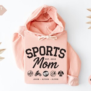 Multiple Sports Mom Hooded Sweatshirt with various sports ball icons, year established and kids names, mixture of college and cursive fonts