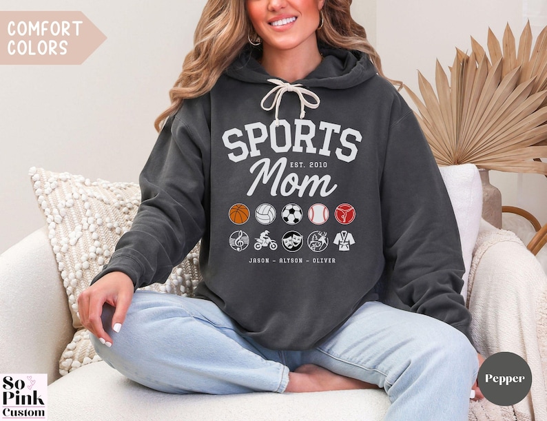 Multiple Sports Mom Hooded Sweatshirt with various sports ball icons, year established and kids names, mixture of college and cursive fonts