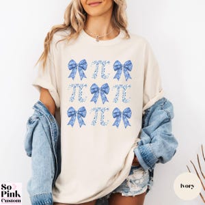 Comfort Colors®  Coquette blue toile de jouy pi shirt with bows and pi symbols laid out in a 3 x 3  grid