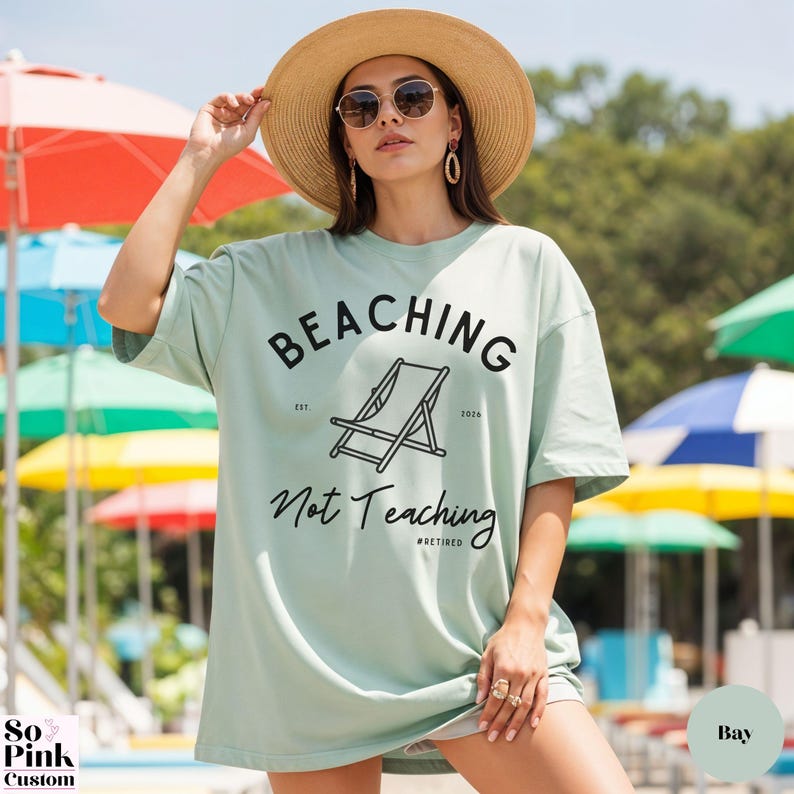 Comfort Colors Shirt with deck chair illustration in the center, curved text above, script below - BEACHING Not Teaching #Retired Year Est. 2026