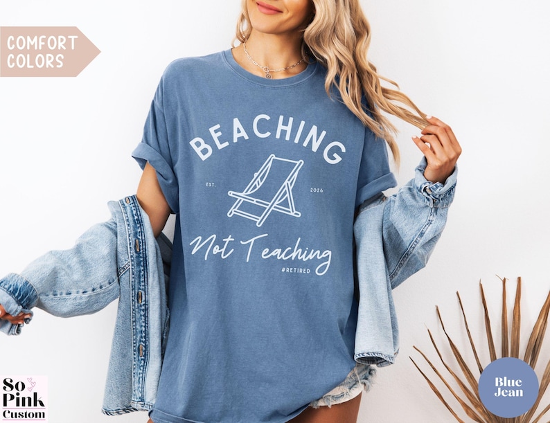 Comfort Colors Shirt with deck chair illustration in the center, curved text above, script below - BEACHING Not Teaching #Retired Year Est. 2026
