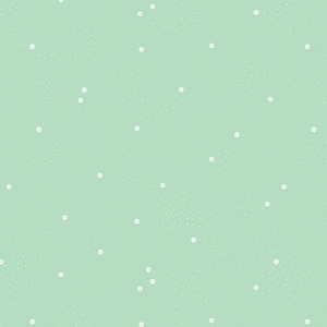 Puede incluir: Tela verde claro con un patrón de pequeños puntos blancos y diminutas motas blancas. Una regla en pulgadas se encuentra en el borde inferior, con el texto "Riley Blake Designs".