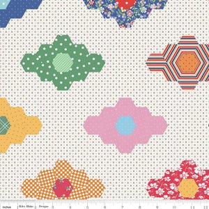 May include: A fabric pattern featuring colorful, hexagonal floral designs. The flowers are in shades of blue, green, yellow, pink, and red, with patterned centers. The background is a light beige with small, dotted details. The image includes an inch ruler.
