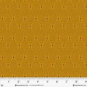 May include: Mustard yellow fabric with a repeating pattern of stylized leaves and dark brown stars. The fabric has a textured appearance and a ruler along the bottom edge. The text "Henry Glass & Co. Inc." is visible.