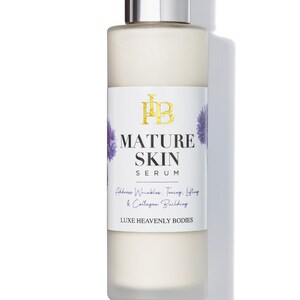 May include: A white bottle of Mature Skin Serum by Luxe Heavenly Bodies. The bottle has a silver pump top and a label with purple flowers.