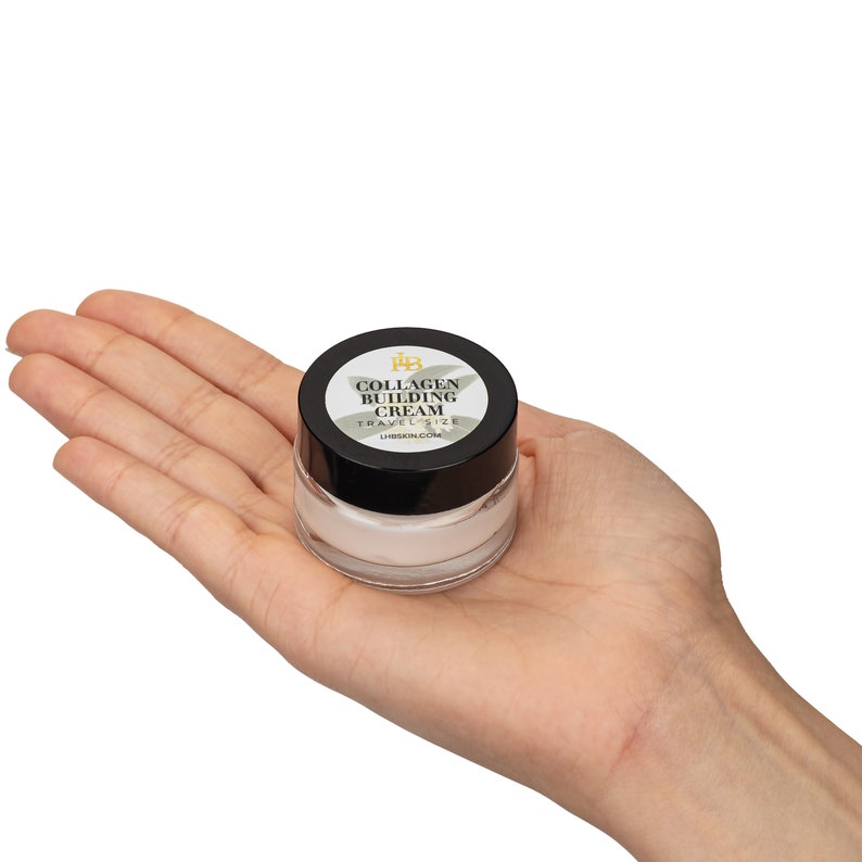 May include: A small, white jar of collagen building cream with a black lid and a label that reads "Collagen Building Cream Travel Size LHSKIN.COM".