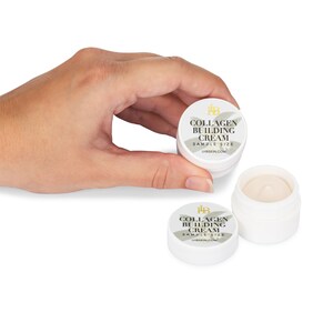 May include: Two small white jars with a gold label that reads "Collagen Building Cream Sample Size" and the website address "lhbskin.com".