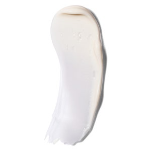 May include: A close-up of a white cream product, smoothly applied in a curved shape against a white background. The cream has a glossy texture, with subtle variations in tone and highlights.