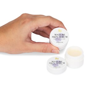 May include: Two small white jars with a purple and gold label that reads "Mature Skin Serum Sample Size" and the website address "LHSKIN.COM".