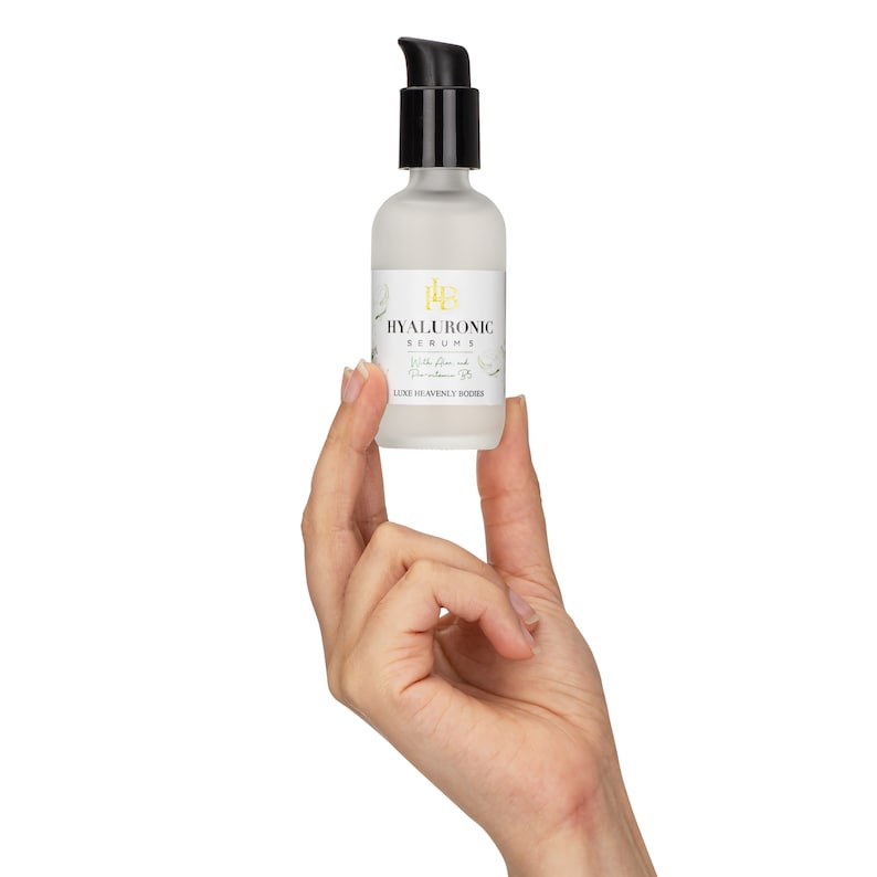 May include: A clear glass bottle with a black pump top and a white label that reads "HYALURONIC SERUMS with Aloe and Hyaluronic Acid LUXE HEAVENLY BODIES".