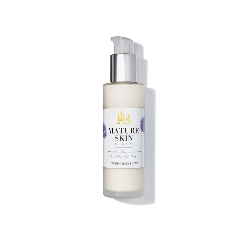 May include: A white bottle of Mature Skin Serum by Luxe Heavenly Bodies. The bottle has a silver pump top and a label with purple flowers.